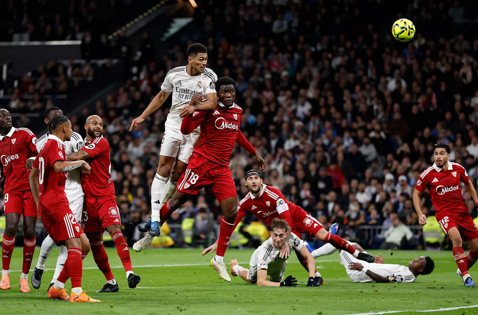 Jugador del Real madrid saltando, cabeceando el balón y ganando a todos los defensores del sevilla.